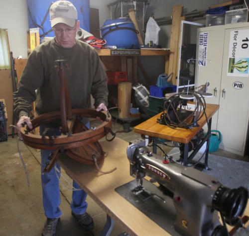 Mike Emich explains the use of an antique envelope vent used in hot air balloons. The sewing machines are used in making hot air balloons. Photo: Michael Chritton/Akron Beacon Journal