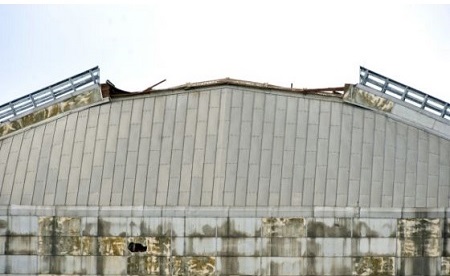 A section of a walkway on the top of the North Tustin blimp hangar collapsed, sending debris down on the Aeroscraft, an experimental helium-filled craft being developed to ferry cargo. The partial roof collapse was reported at 7:45 a.m. Monday at the former base, said Capt. Steve Concialdi of the Orange County Fire Authority. Photo: Sam Gangwer, Orange County Register 