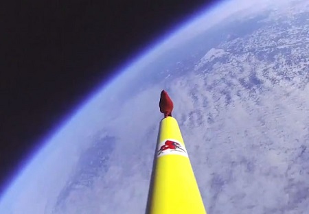 The cardinal sits perched on a PVC pipe attached to a weather balloon that floats at the outer edge of the atmosphere as it records the Earth from more than 100,000 feet up, just seconds before the balloon burst.