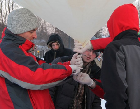 Chi-Hi physics teacher, Nick Gagnon, left, and members of the club prepare the weather balloon for launch Friday morning in the parking lot of Chi-Hi.