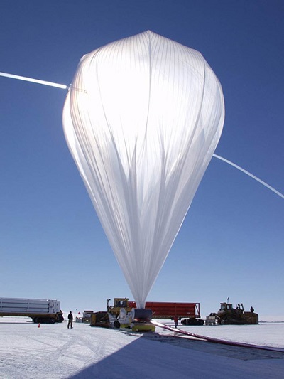 High-pressure helium from Kelly trucks carrying gas cylinders rushes through fill tubes extending from the top of a balloon that is pinned to the ground by a spool truck. The rest of the balloon’s flight train is laid out on the ground to the right. The photos in this article were taken during several different balloon campaigns, this one in Antarctica. Photo: NASA