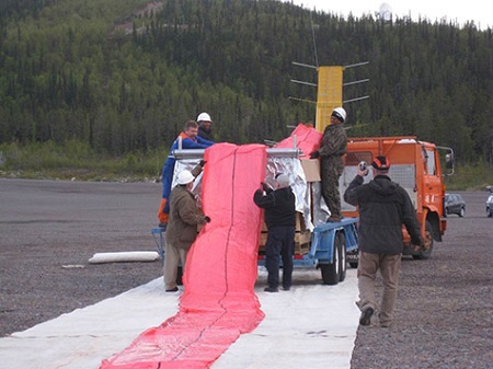 The fan-folded balloon is delivered to the launch site in an enormous crate. Here the crew is carefully pulling it from the crate and laying it onto a protective tarp prior to launch.  Photo: NASA