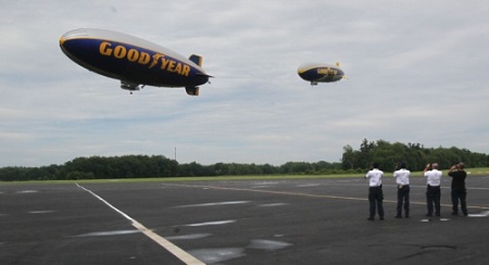 The ground crew watches as the Goodyear airships Spirit of Innovation (left) and Wingfoot One take flight at the company's airship base in Suffield Township on Wednesday.  Photo: Michael Chritton/Akron Beacon Journal