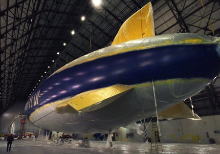 Jim Westfall, an employee with Thomarios in Copley, applies yellow paint to a detail line on Goodyear's new airship inside the Wingfoot Lake hangar in Suffield Twp., Ohio. Photo: Ed Suba Jr. - Akron Beacon Journal