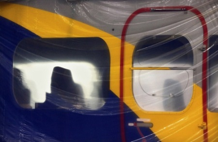 The gondola of Goodyear's new airship is protected by plastic as employees with Thomarios in Copley, apply another coat of blimp blue V2.  Photo: Ed Suba Jr. - Akron Beacon Journal.
