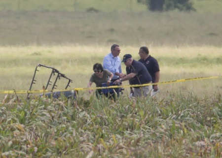 The partial frame of a hot air balloon is visible above a crop field as investigators comb the wreckage of a crash Saturday morning, July 30, 2016, near XXX, Texas. Authorities say the accident caused a "significant loss of life." Image: Ralph Barrera/Austin American-Statesman via AP.